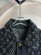 Dark denim jacket front close-up with monogram print, snap buttons, and hanging tag.