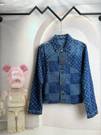 Blue denim jacket with raised collar and gold snap buttons on front