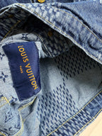 Blue denim jacket interior label with gold text reading "Louis Vuitton"