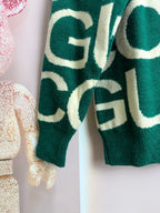Green knit sweater with cream logo lettering, long sleeves detail
