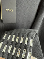 Dark gray knit sweater detail with studded strip embellishment