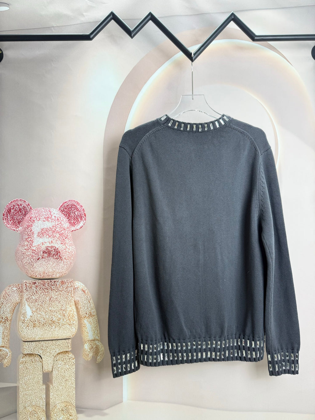 Dark gray long-sleeve sweater with studded trim along cuffs and hem