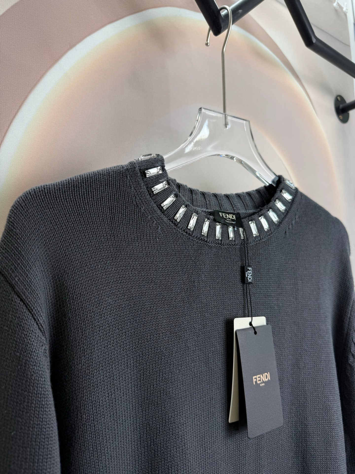 Dark gray long-sleeve sweater with studded neckline trim and button placket