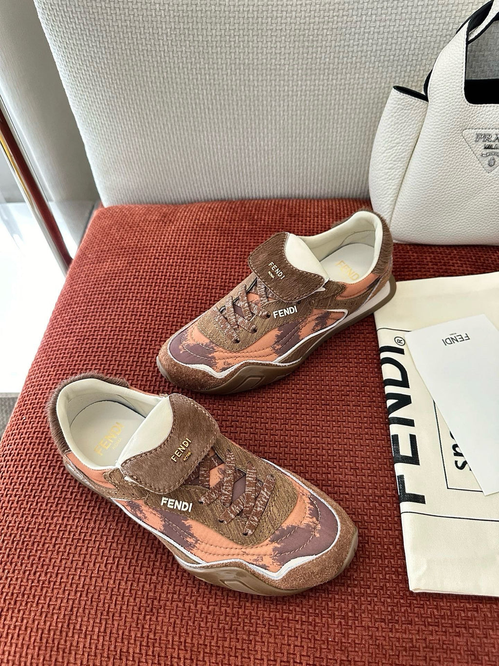 Brown and pink patterned sneakers with white sole, lace-up front, and FENDI logo.