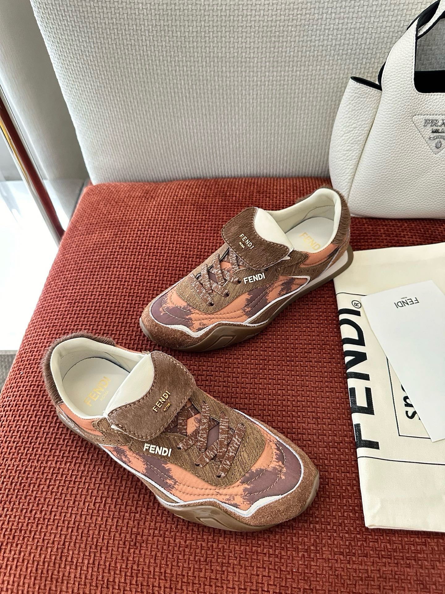 Brown and pink patterned sneakers with white sole, lace-up front, and FENDI logo.