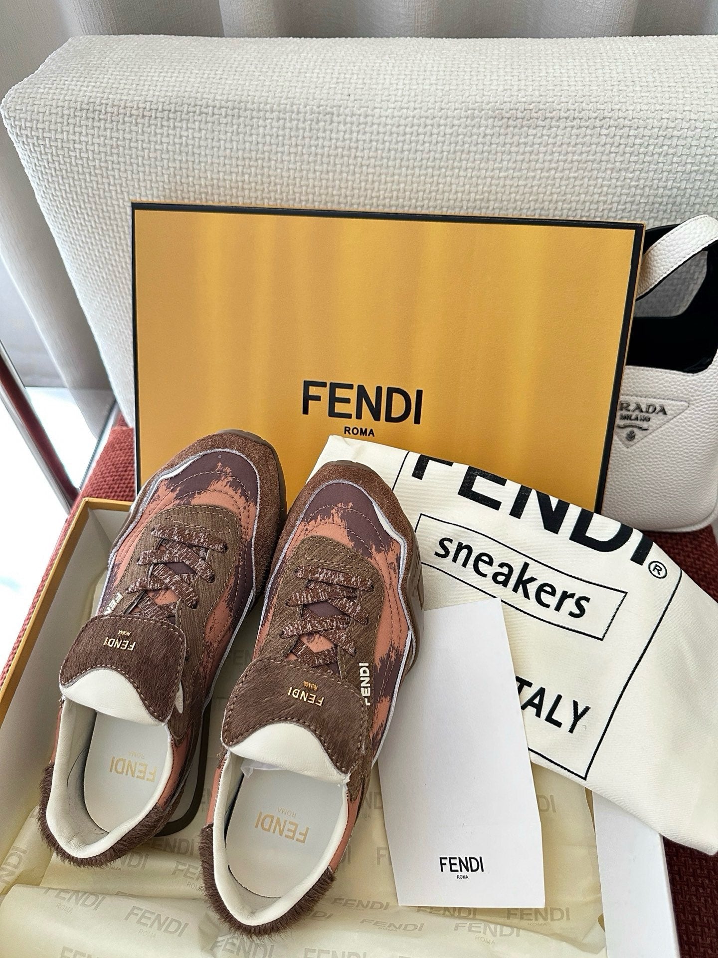 Brown and pink patterned sneakers with white sole and FENDI branding on side panels.