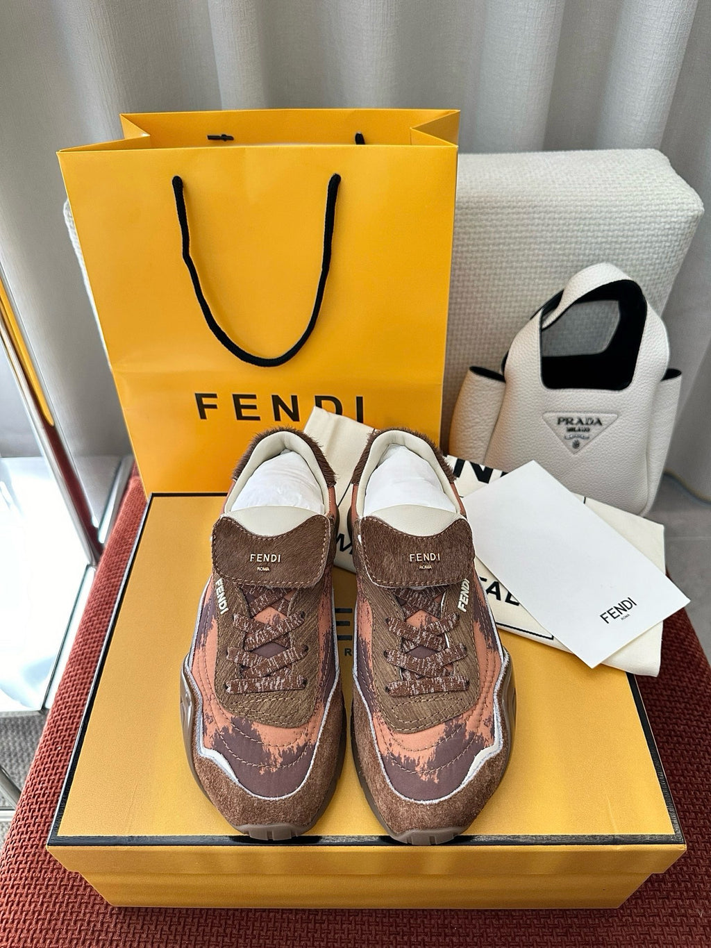 Brown and pink patterned lace-up sneakers with white sole and FENDI logo branding.
