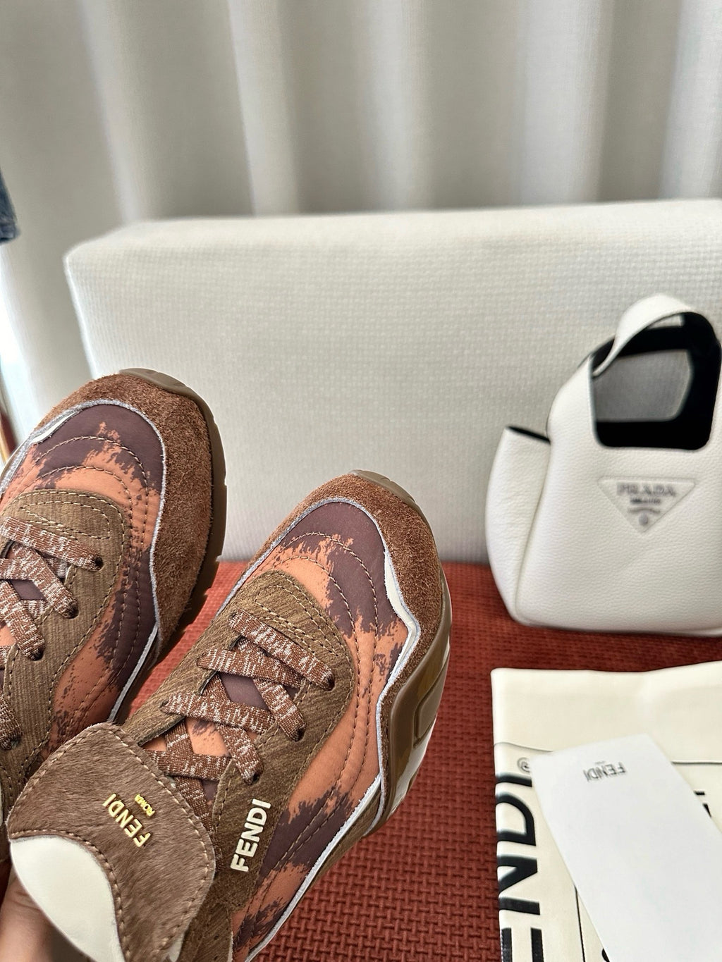 Brown and pink patterned sneakers with FENDI logo detail and white rubber sole.