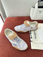 Fendi unisex sneakers on red surface, light blue-gray uppers with tan suede heel and lace eyelets