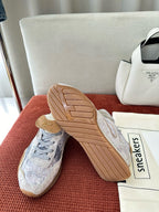 Fendi unisex sneakers with light blue-gray uppers, showing tan rubber outsole and side panels