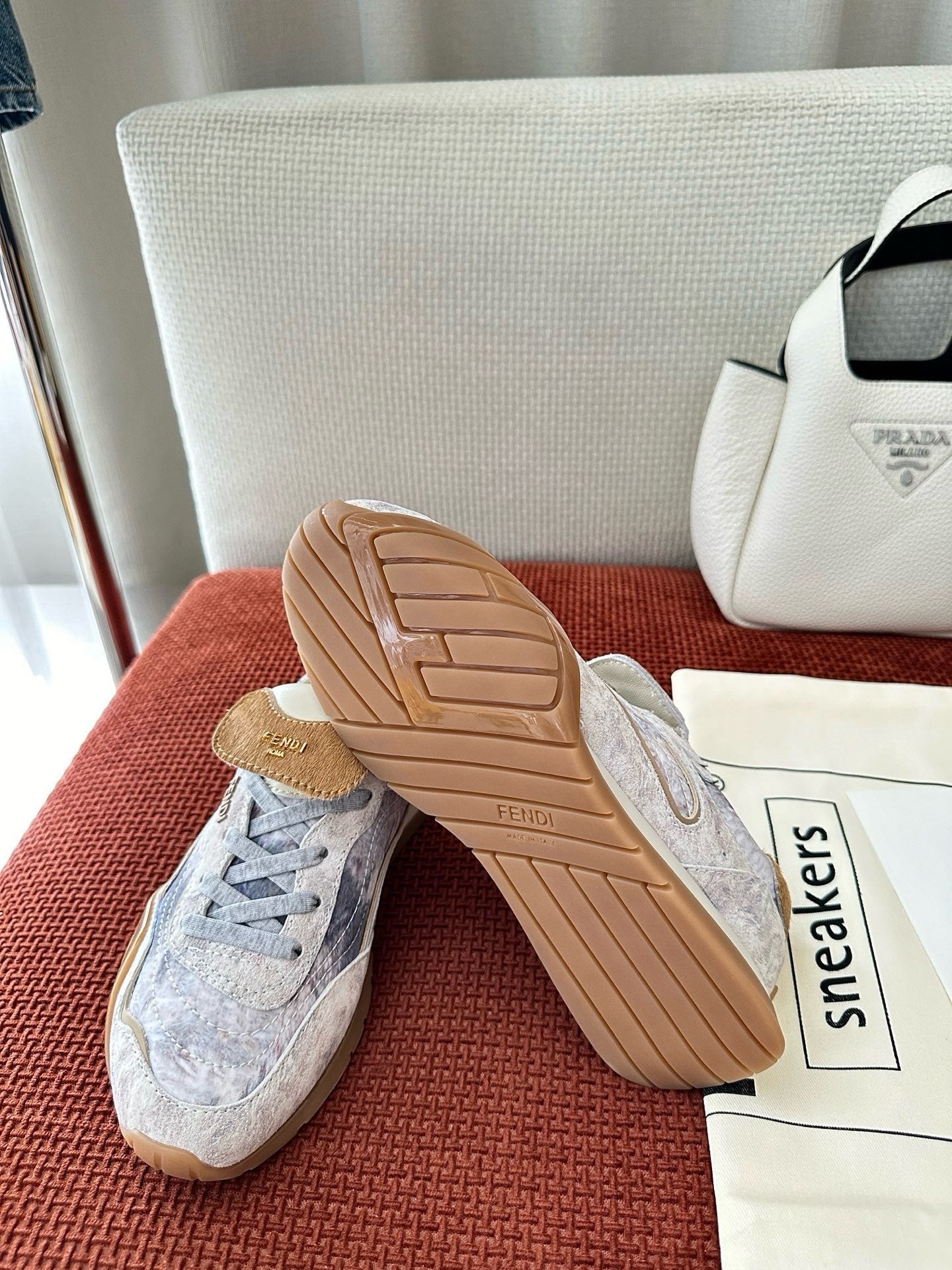 Fendi unisex sneakers with light blue-gray uppers, showing tan rubber outsole and side panels