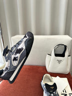 Unisex sneakers side view, navy-and-white splatter print with lace-up front and black heel.