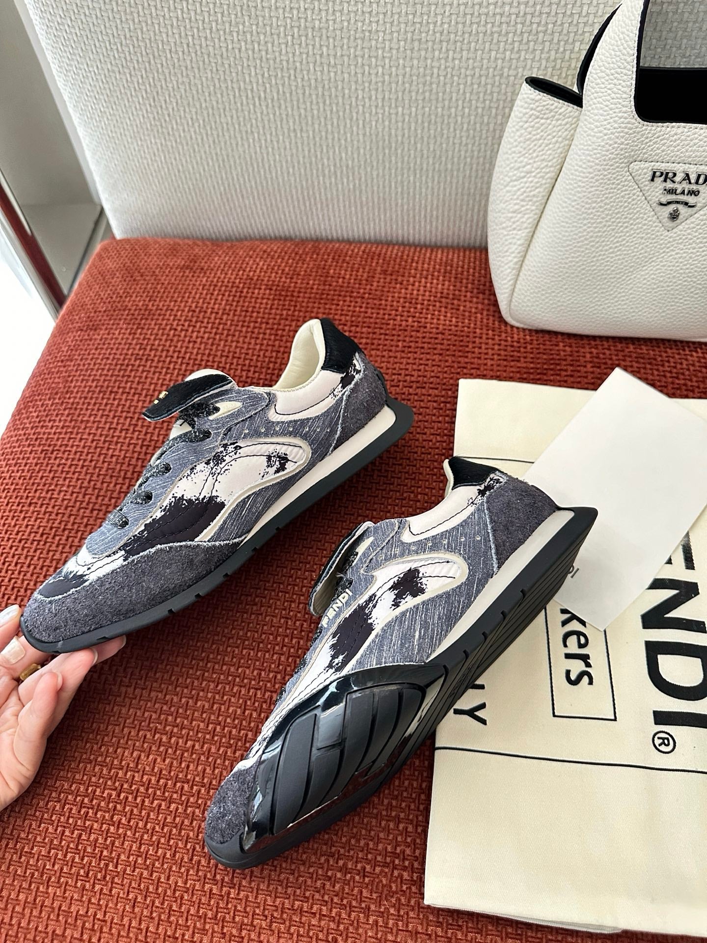 Unisex sneakers two-quarter view: navy-and-white print, lace-up, black tread outsole.