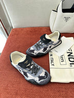 Unisex sneakers top-down view: navy-and-white pattern, lace-up, chunky rubber sole.