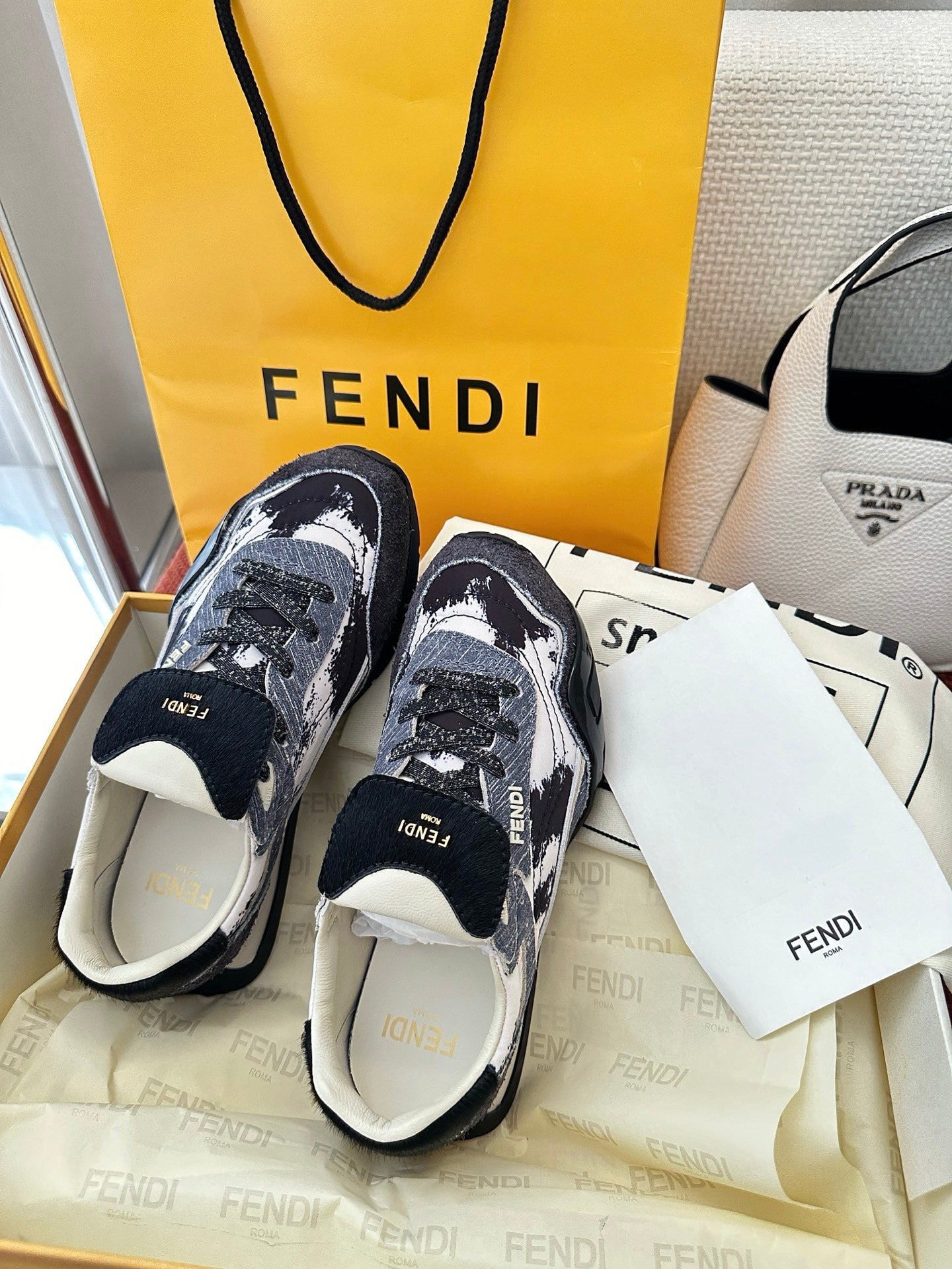 Pair of unisex sneakers in dark blue and white pattern, lace-up, thick sole, side view.