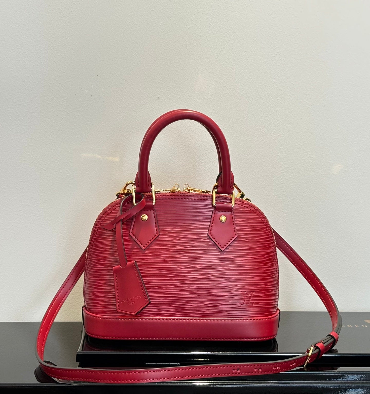 Louis Vuitton red Epi-style handbag with top handles and shoulder strap