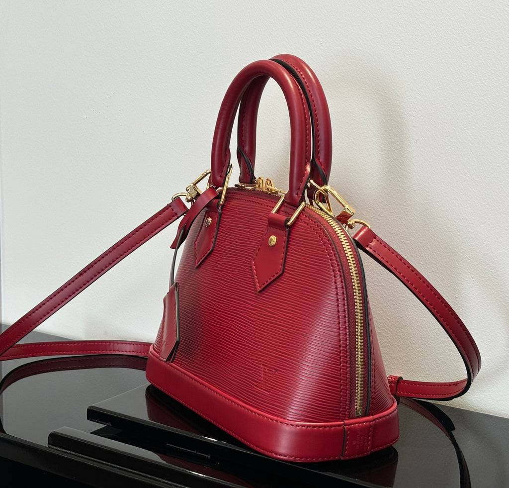Louis Vuitton red Epi-style handbag with crossbody strap and zip top