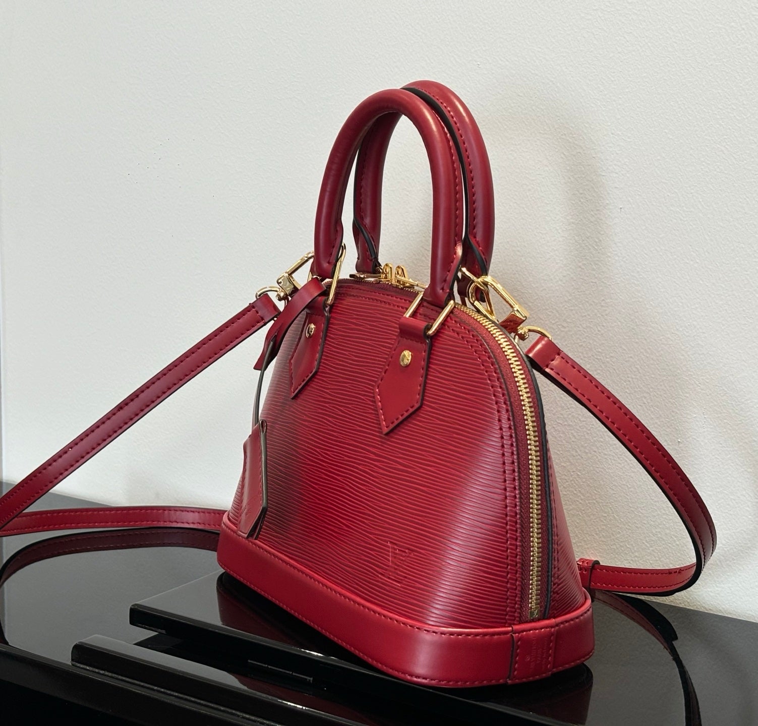 Louis Vuitton red Epi-style handbag with crossbody strap and zip top