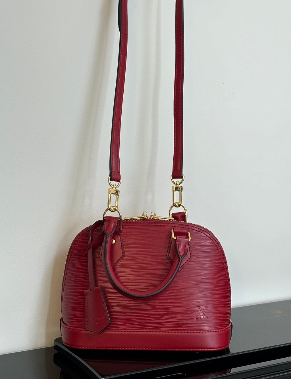 Louis Vuitton red Epi-style handbag with twin top handles and long shoulder strap