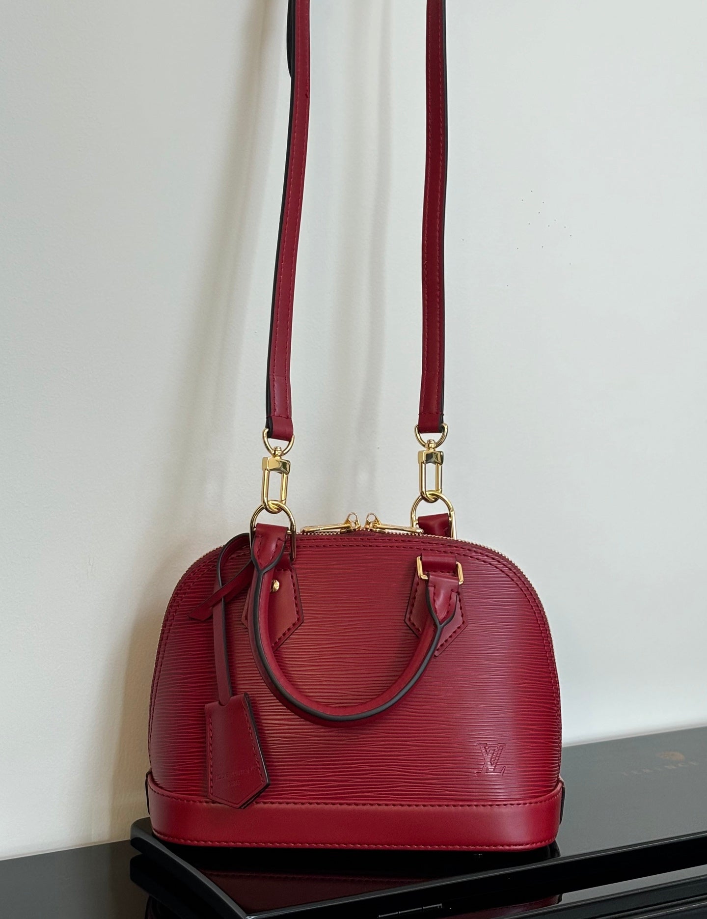 Louis Vuitton red Epi-style handbag with twin top handles and long shoulder strap