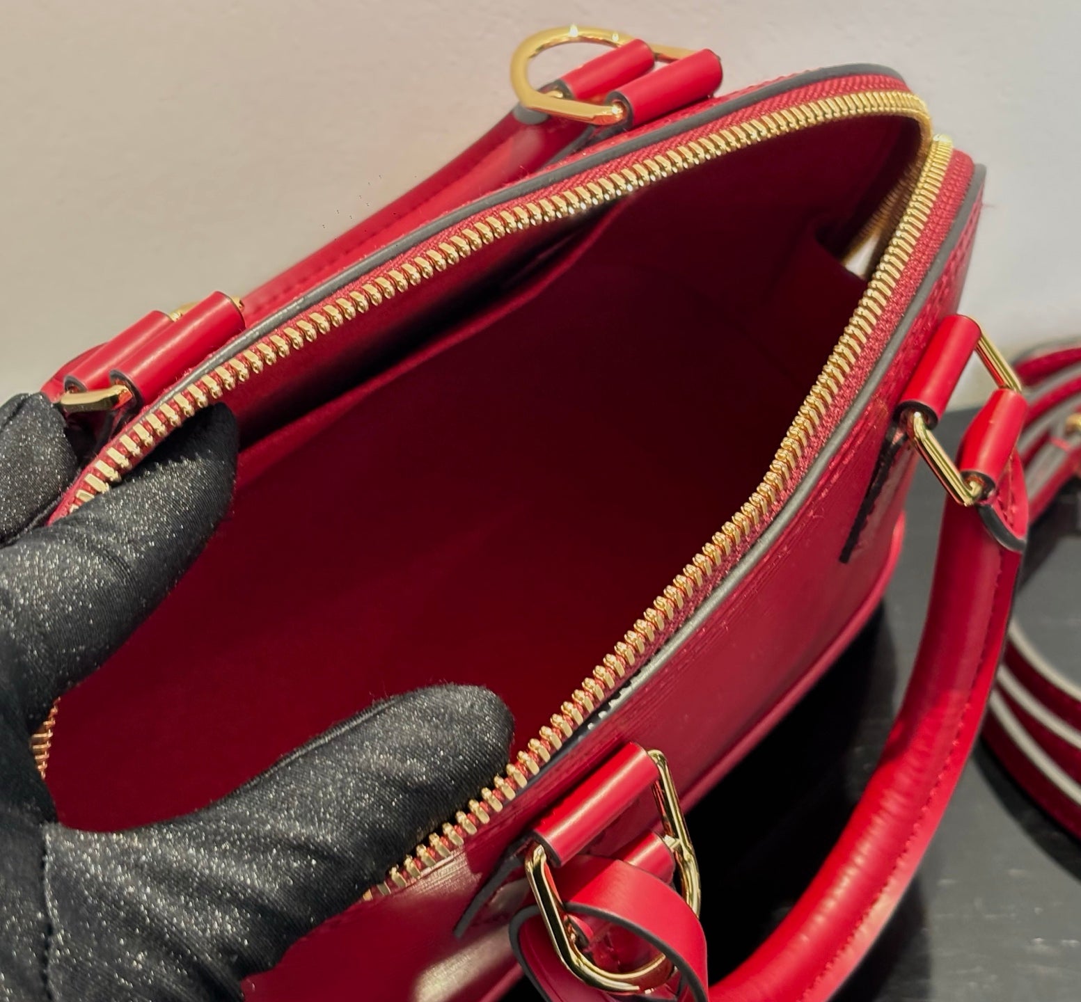 Louis Vuitton red handbag interior view with red lining and gold zip closure