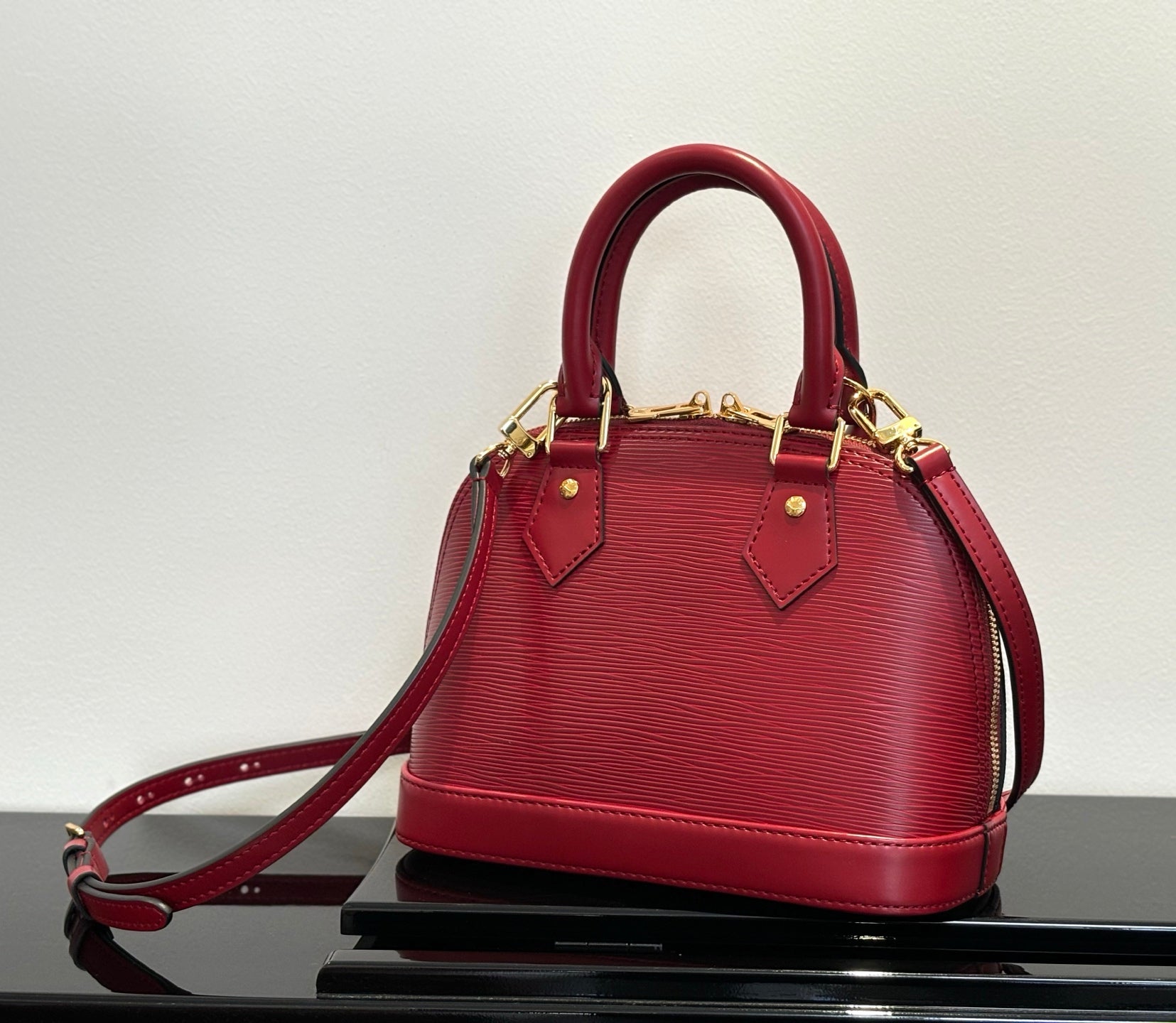 Louis Vuitton red Epi-style handbag with gold-tone hardware and top handles