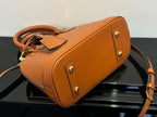 Tan leather handbag with top handle and crossbody strap, gold-tone hardware