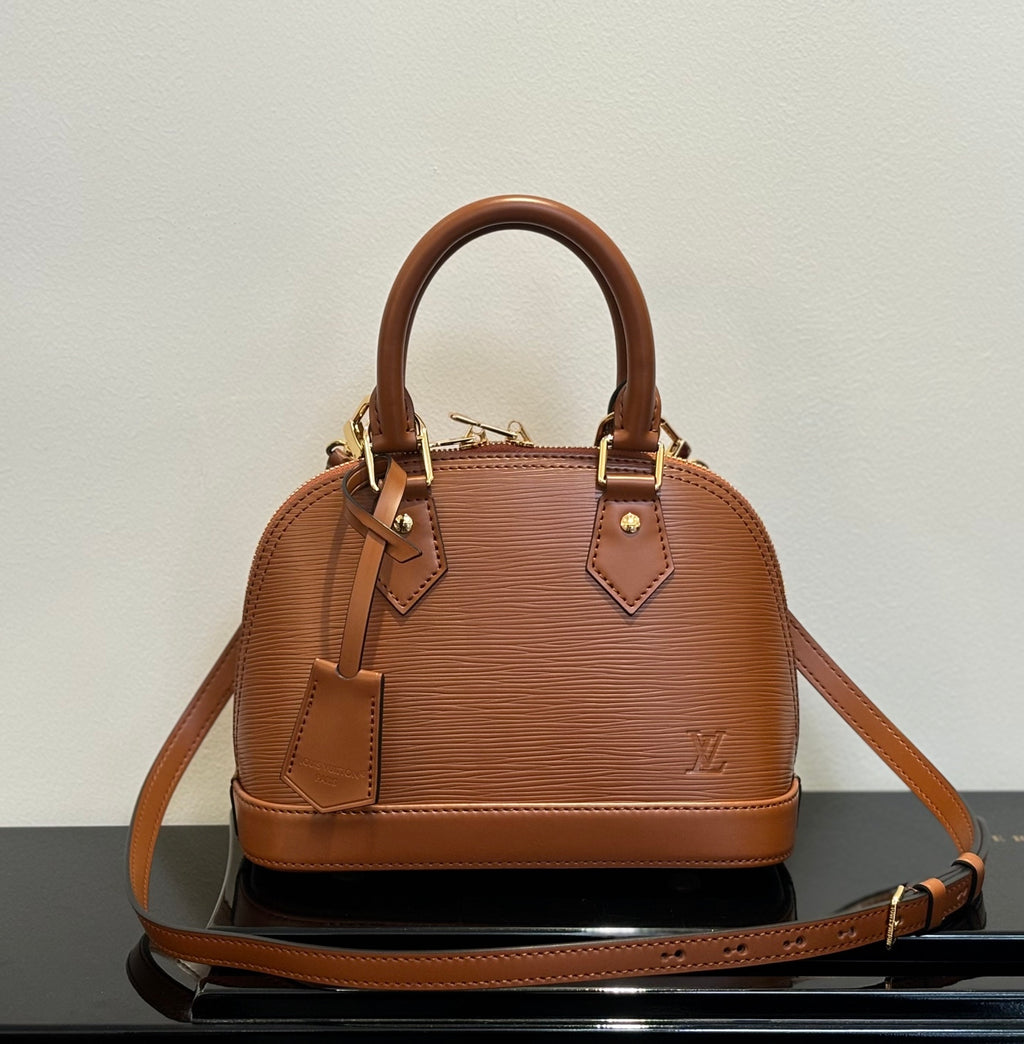 Louis Vuitton leather handbag in tan, top handles, crossbody strap, structured dome shape