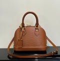 Louis Vuitton leather handbag in tan, top handles, crossbody strap, structured dome shape