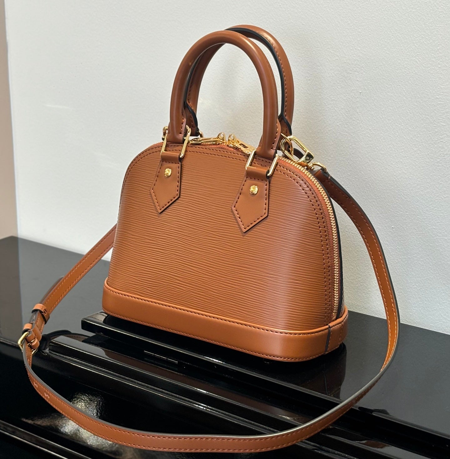 Louis Vuitton leather handbag in tan with top handles and adjustable crossbody strap