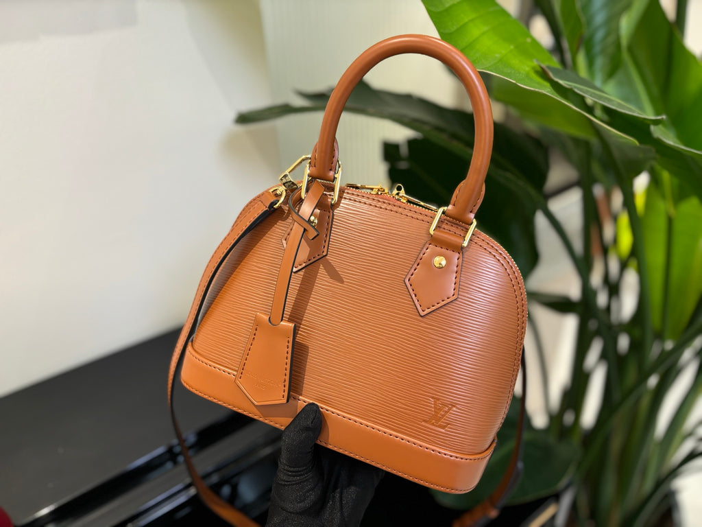 Tan leather handbag with top handles, gold-tone hardware, and crossbody strap