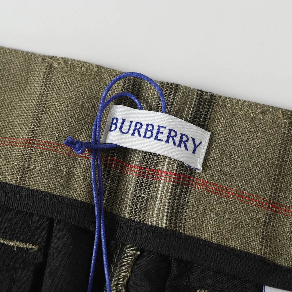 Woven brand label on olive plaid pants with blue drawstring tie
