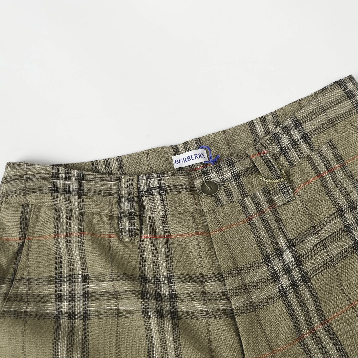 Waistband of olive plaid pants with belt loops, button, and dark side tab