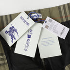 Inside view of olive plaid pants with attached tag and fabric information labels