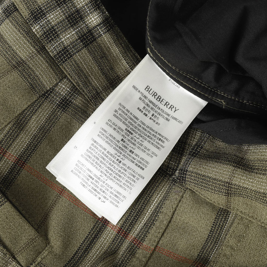 Brand tag on plaid pants with button placket and pleated front detail