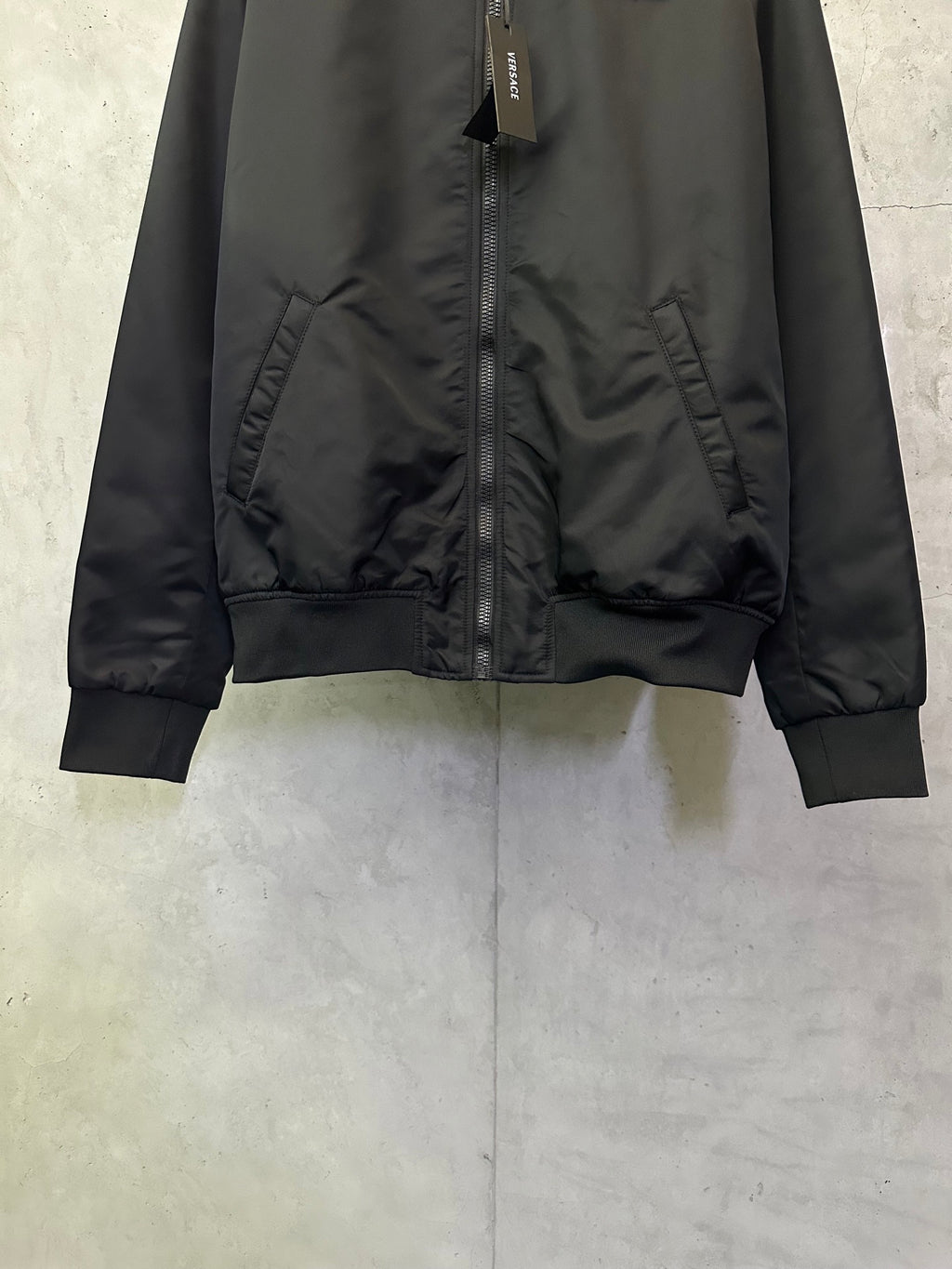 Black Versace bomber jacket with front zip, gathered pocket panels and ribbed cuffs