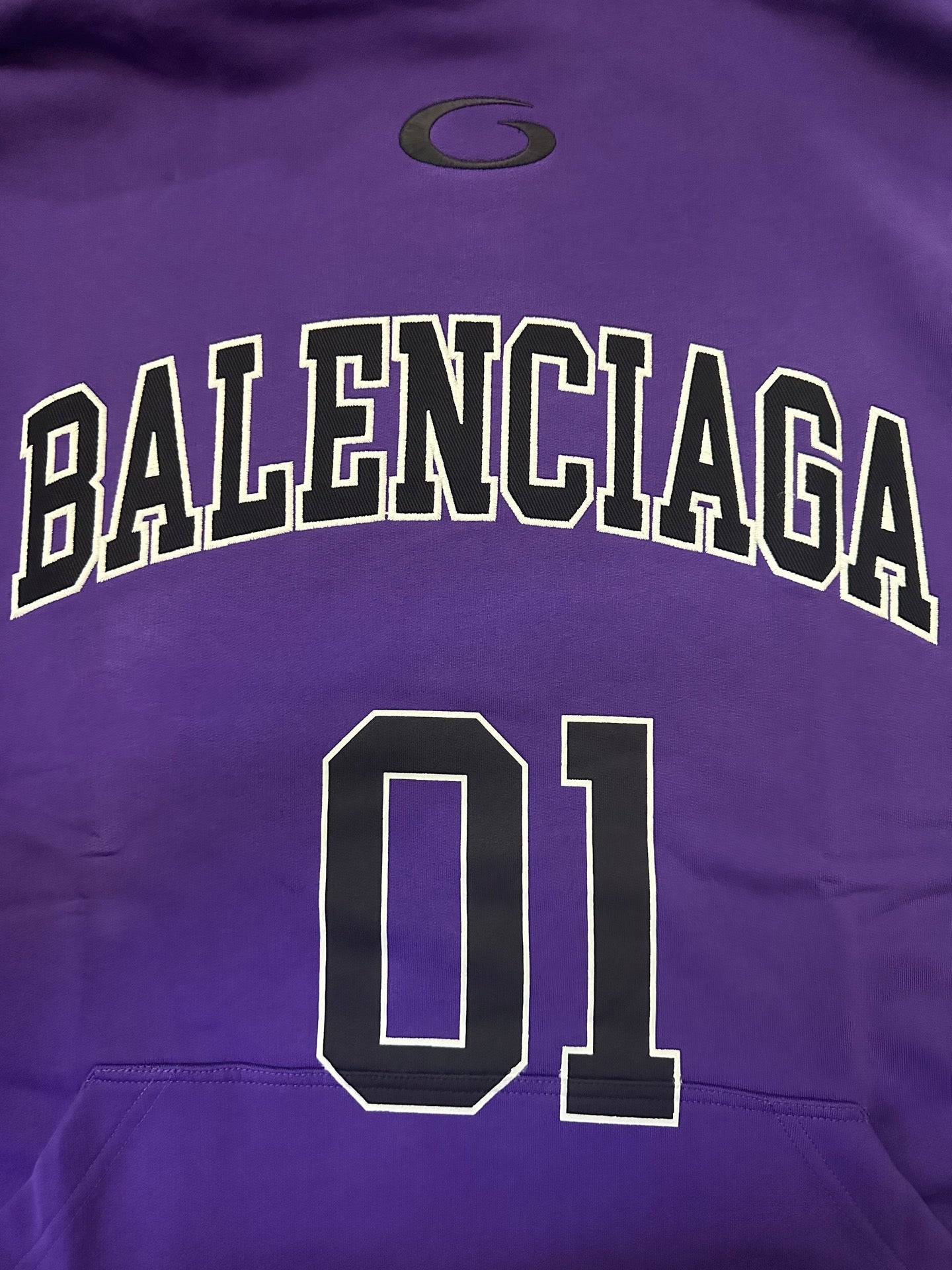 Purple Balenciaga hoodie close-up of 'BALENCIAGA' text and '01' number