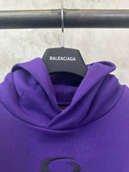 Purple Balenciaga hoodie hood close-up with small green oval emblem