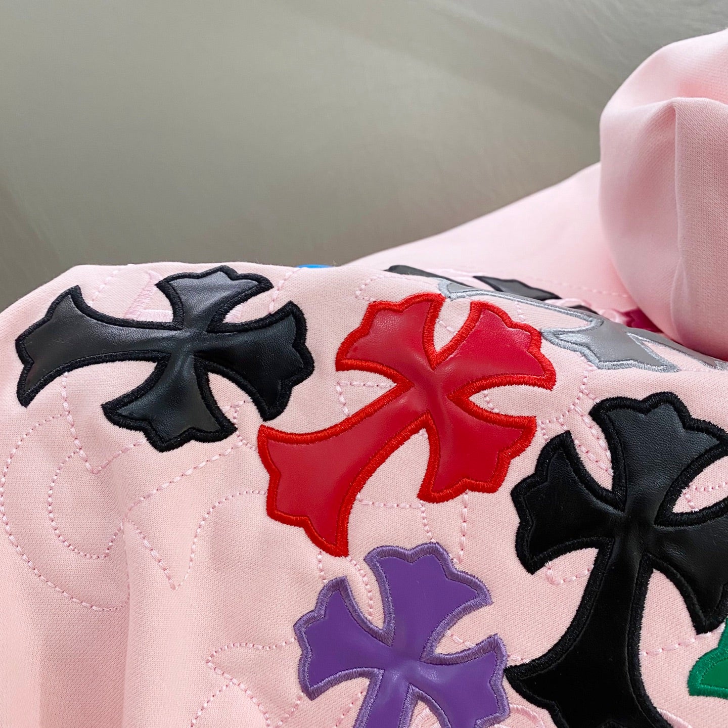 Pink hoodie shoulder and back with embroidered multicolor clover/star applique