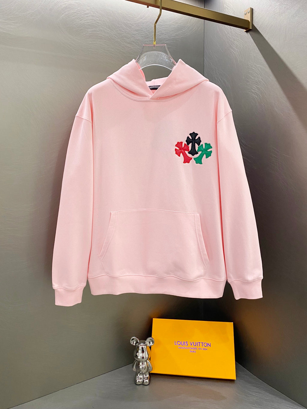 Pink long-sleeve hoodie with front pocket and multicolor clover/star applique