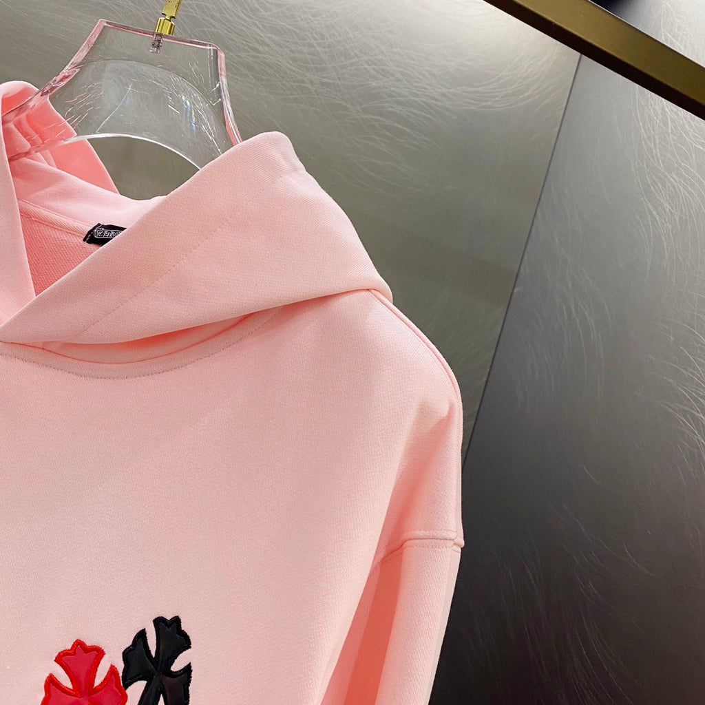 Pink long-sleeve hoodie with small red and black applique on the side