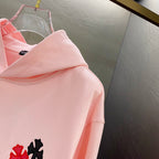Pink long-sleeve hoodie with small red and black applique on the side
