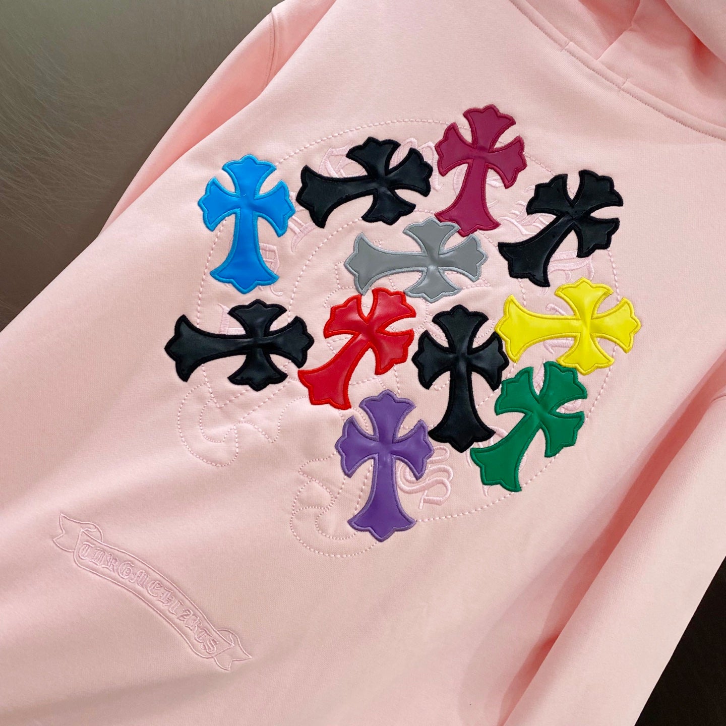 Pink hoodie with multicolor clover/star applique detail on the chest