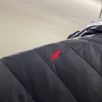 Navy quilted jacket with red embroidered logo on upper sleeve