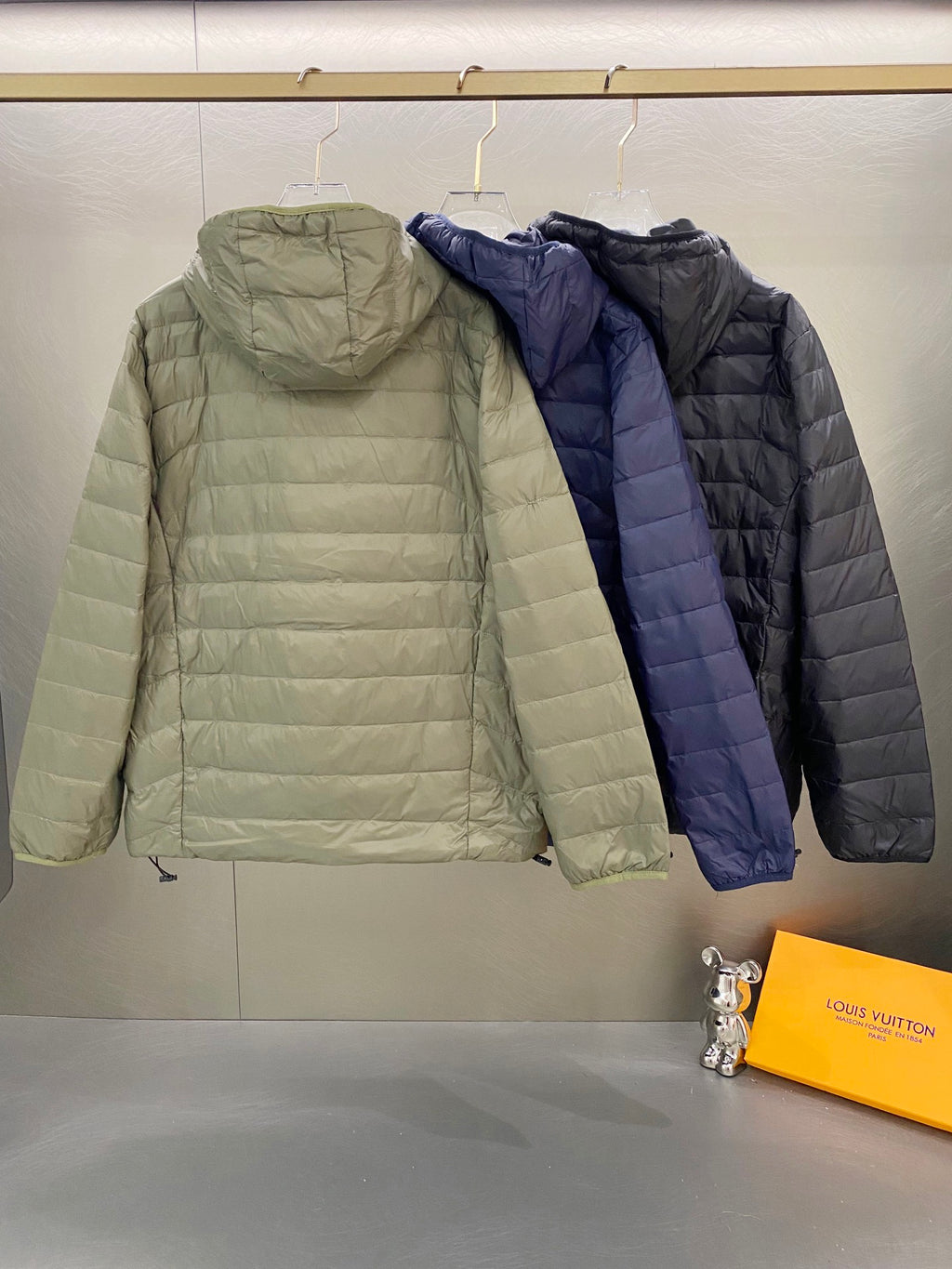 Light green and navy quilted hooded jackets with full zips and drawstring hems