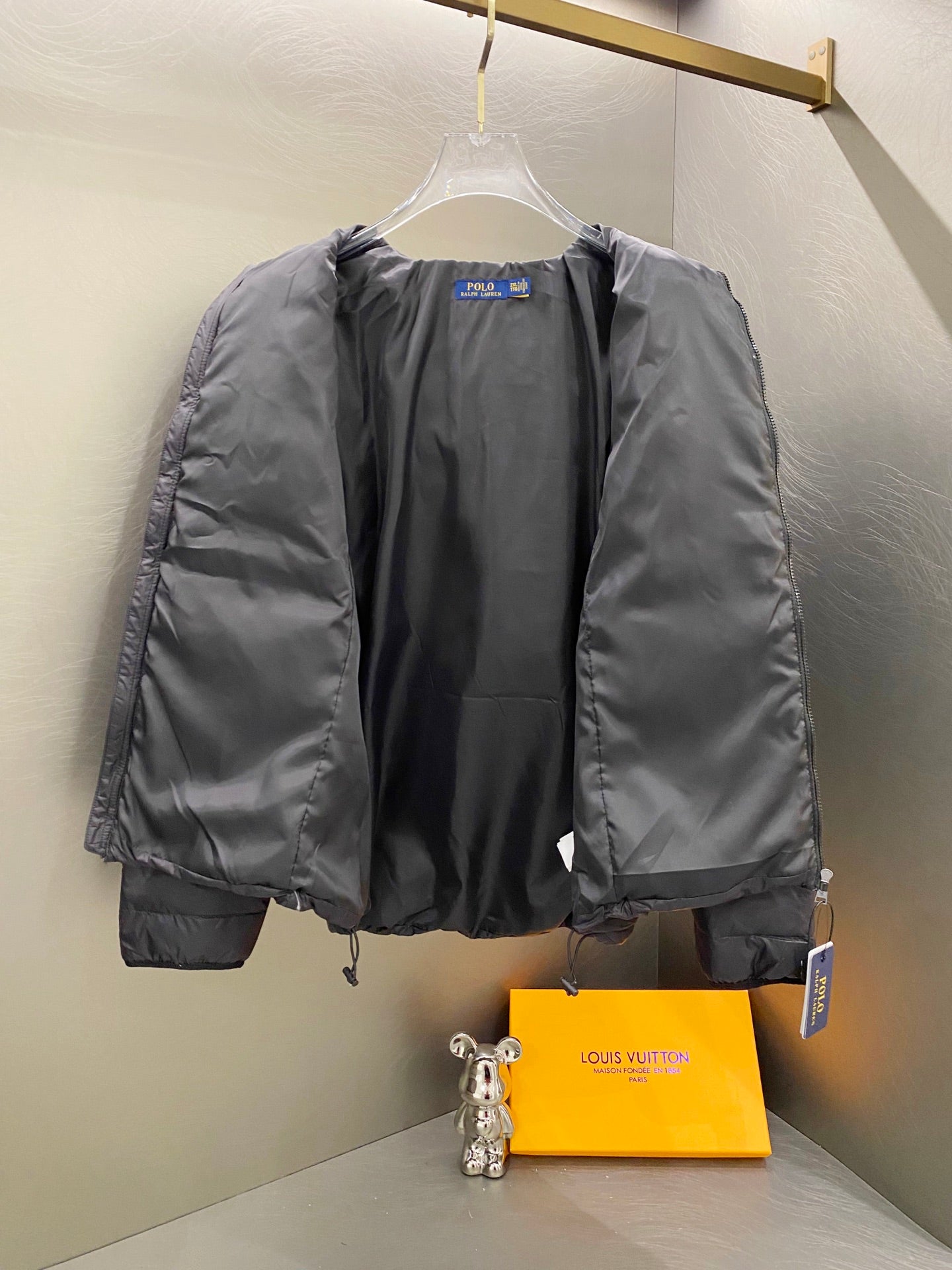 Ralph Lauren puffer jacket on hanger with front zipper and stand collar, dark charcoal