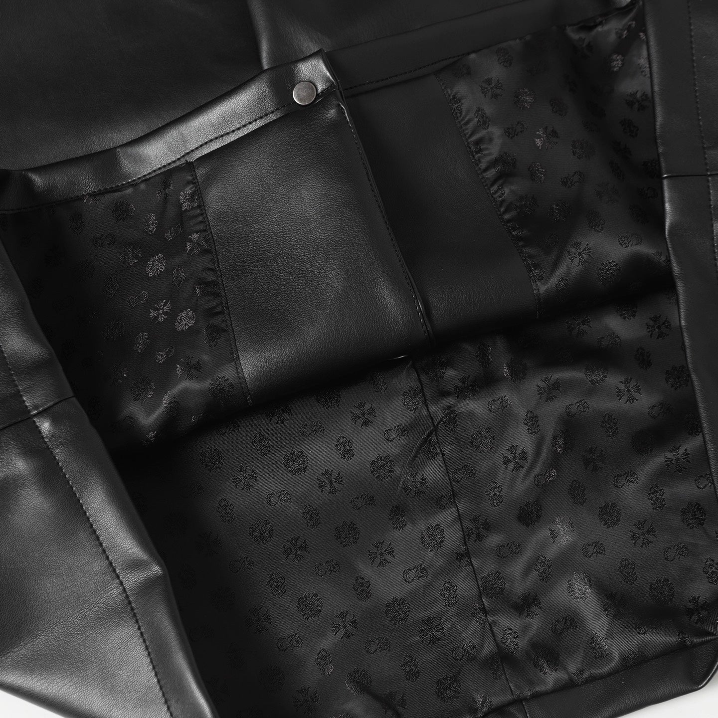 Black long pants with front seams, button tab, and embossed pattern panels