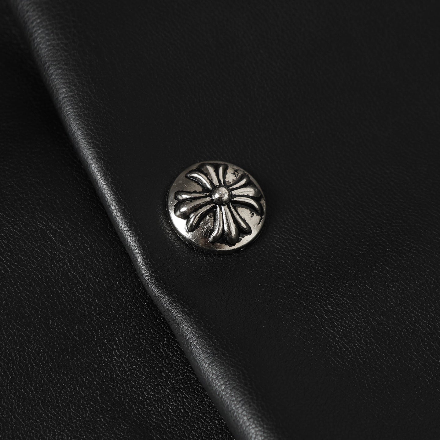 Black leather jacket with round silver-tone snap button