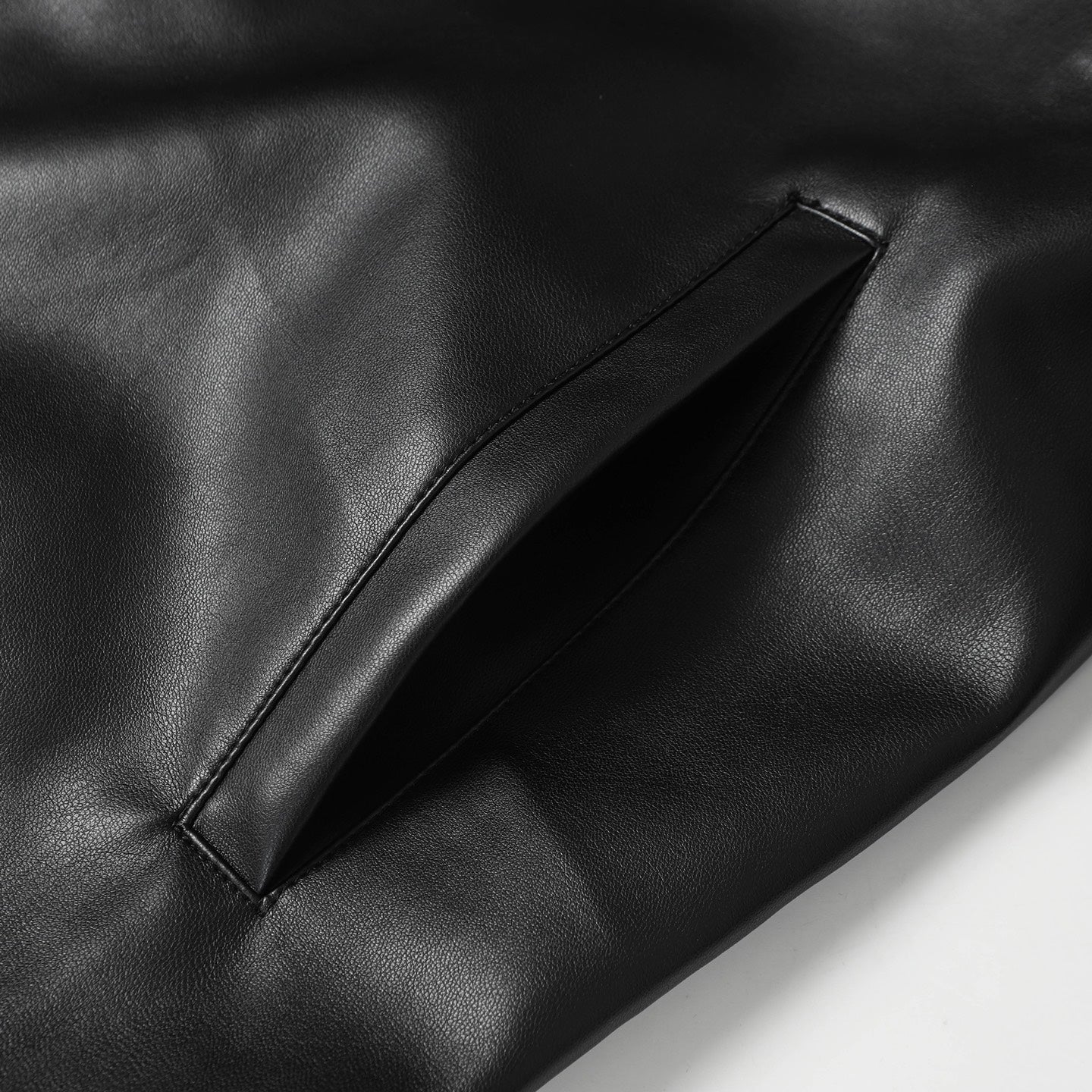 Black leather jacket front pocket seam and leather panel detail