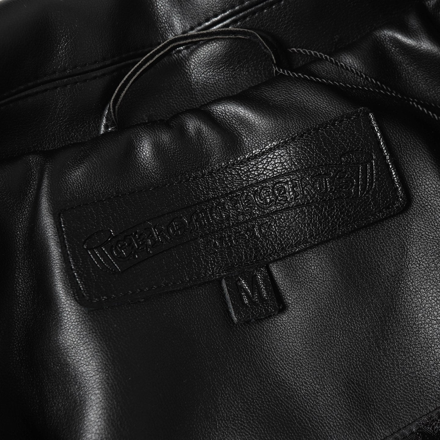 Black leather jacket neckline with inner label and snap detail